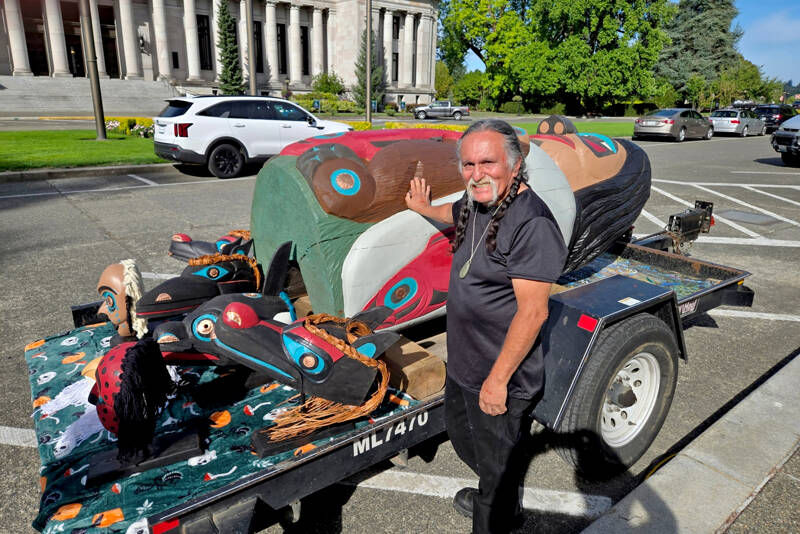 Lummi master carver Jewell James stands with the totem pole at a rally in Olympia. (Se’Si’Le)