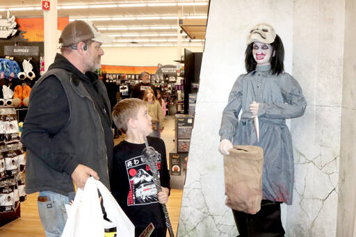 Leif Bishop, 9, and his father Jason Bishop are taken aback by a scary prop at Spirit Halloweens entrance, which suddenly pulls up its mask to a scary sound. The seasonal store has opened at 1940 E. First St. in Port Angeles Plaza in the former Big Lots location. Spirit Halloween has been in Sequim for the past four years, but it migrated to Port Angeles this year. The chain store has more than 1,400 locations across North America this time of year. It sells costumes, decorations, props and accessories during the Halloween season. Store hours are from 10 a.m. to 10 p.m. every day through Halloween. It closes at 9 p.m. on Sundays. (Dave Logan/for Peninsula Daily News)