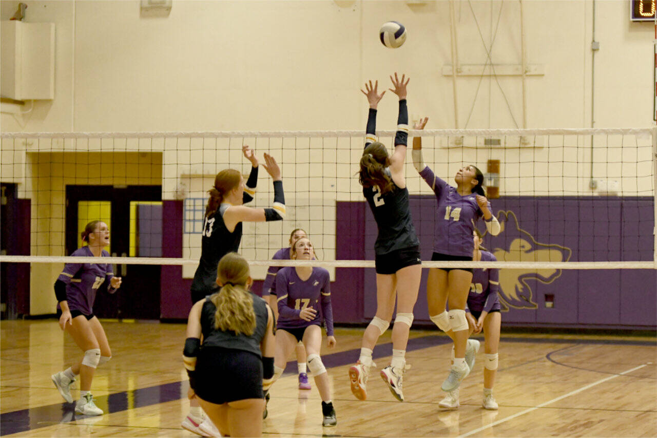 Sequim's Kassi Montero battles above the net against unbeaten Bainbridge in a match Tuesday in Sequim. Also in on the play are Sequim's Kenzie Berglund (23) and Teagan Neathery (17). (Jacques Star/Olympic Peninsula News Group)