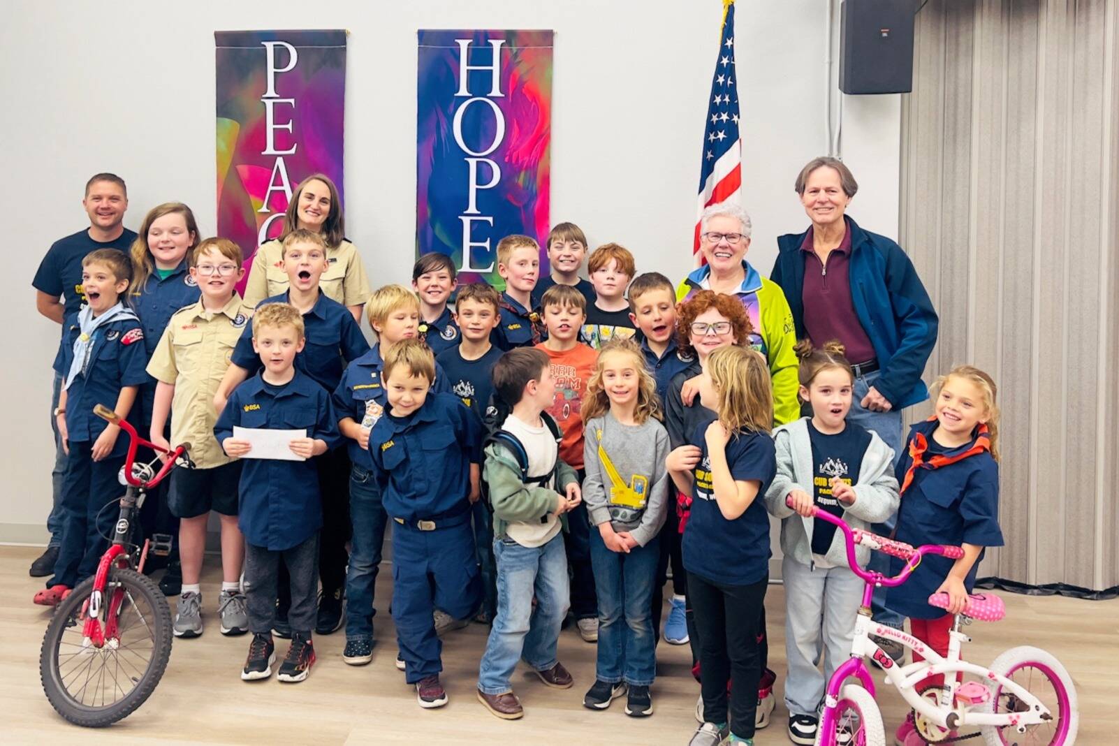 Olympic Peninsula Bicycle Association (OPBA) members, on top right, Jean Robards and Frank Finney present a grant worth $3,969 to Sequim Cub Scout Pack 4490 led by Pack Leader Fran Olsen and scouts. The Scout Pack also received equipment for the Sequim Bike Rodeo to continue the educational event. (Olympic Peninsula Bicycle Association)
