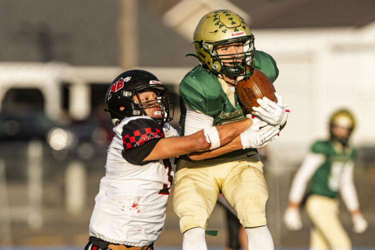 DeSales Maddox Filan catches a pass from quarterback Cohen Wood before Neah Bays Caleb Cummins tackles him during their 2025 their class 1B championship football quarterfinal at Walla Walla High School on Saturday. Neah Bay stayed close to DeSales until the fourth quarter when the Fighting Irish scored 22 straight points to win 58-24. Neah Bay, which traveled 1,830 miles to play its two state playoff games in Colfax and Walla Walla, finished its season with an 8-3 record. (Kezia Setyawan/Walla Walla Union-Bulletin)