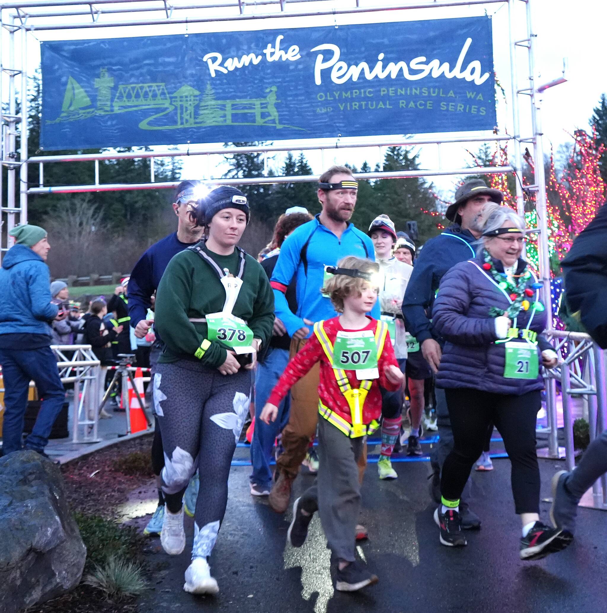 Aaliyah Clark of Poulsbo (378) and Monica Castleberry of Lacey (21) lead a young runner at the start of the Jamestown SKlallam Glow Run in Blyn late Saturday afternoon. The race had a record-breaking 900 participants this year. (Michael Dashiell/Jamestown SKlallam Tribe)