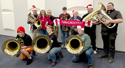 A dozen tuba and euphonium players from the Sequim City Band gather with their instruments and a signature red TubaChristmas scarf as they prepare for this years TubaChristmas performance in Port Angeles. (Sharron McClelland/Sequim City Band)