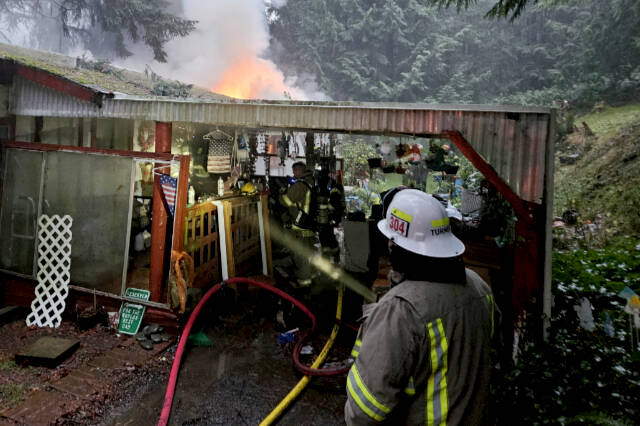 Clallam 2 Fire-Rescue personnel fight a residential structure fire in the 2000 Block of Dan Kelly Road on Wednesday. (Clallam 2 Fire Rescue)