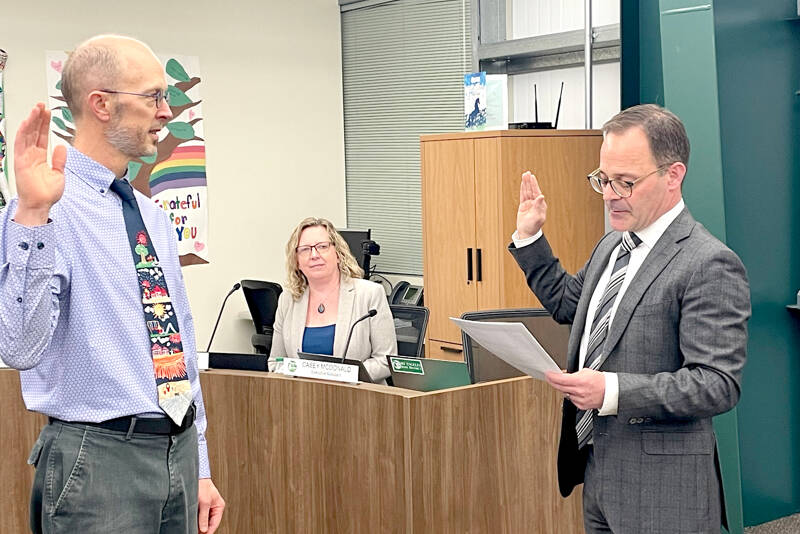 Ned Hammar, left, is sworn in as Port Angeles School District Position 2 director by Clallam County Superior Court Judge Simon Barnhart on Thursday as Superintendent Michelle Olsen looks on. (Paula Hunt/Peninsula Daily News)