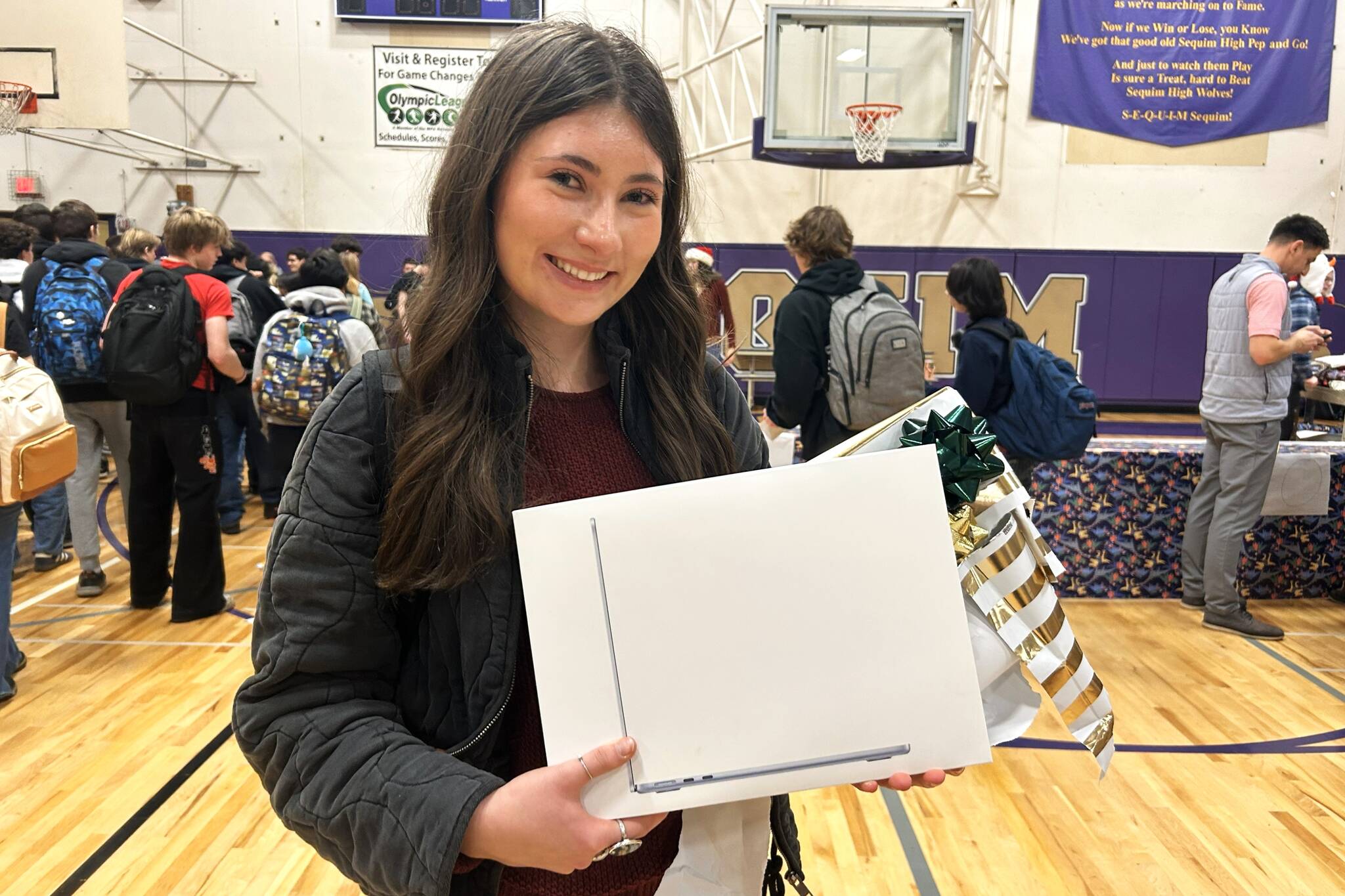 Kendra Dodson holds a new MacBook she received through the Winter Wishes assembly at Sequim High School. Im just blown away by my teachers, she said. Our staff is very amazing. I feel very lucky. (Matthew Nash/Olympic Peninsula News Group)