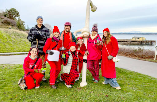 Anita La Salle, kneeling in the center, poses with her family of son, daughters, son-in-law and grandkids, all from Port Townsend, after spending Saturday on a scavenger hunt and celebrating a reunion to welcome a long-lost family member who hasnt been seen in more than 50 years. The hunt originated at the Port Townsend Goodwill, where they each had to buy matching clothes, and took them to various venues around Port Townsend culminating at the anchor at Fort Worden State Park. This is the first Christmas they have all been together as a family. (Steve Mullensky/for Peninsula Daily News)