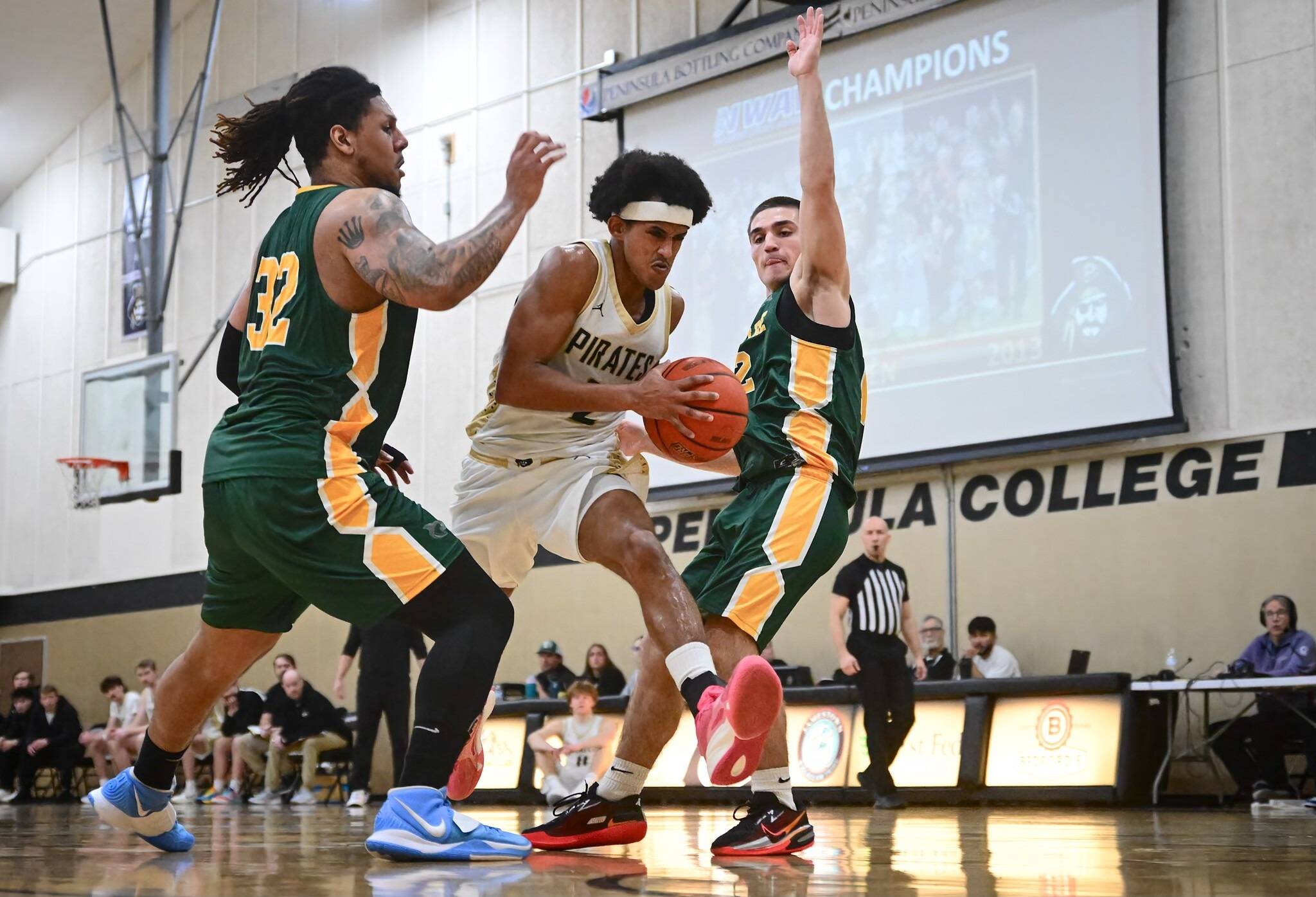 Jay Cline(2)/Peninsula College Athletics 
Peninsulas Sam Tekeste steps through a pair of Shoreline defenders on his way to the rim during the Pirates 75-63 win over the Dolphins on Wednesday.