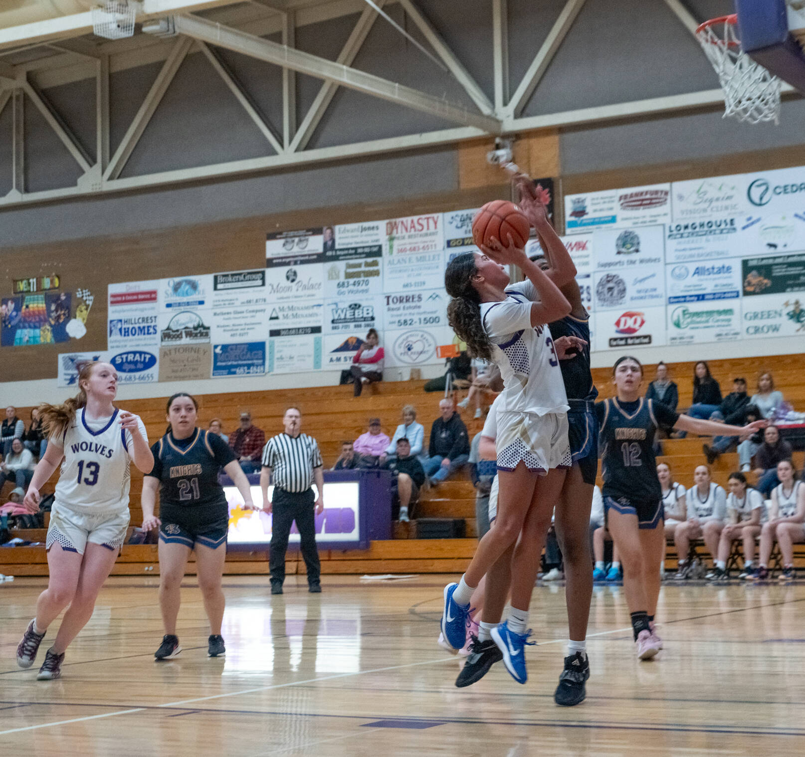 Emily Matthiessen/for Peninsula Daily News 
Sequims Jordyn Julmist is closely defended while putting up a shot attempt against Bremerton as teammate Vaeh Owens, far left, looks on during the Wolves win over the Knights at Rick Kaps Gymnasium on Thursday.