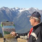 Bill Rogers of Nova Scotia, Canada, paints a watercolor of the Olympics from Hurricane Ridge Visitor Center on Wednesday. In celebration of the National Park Service centennial, artists are painting as part of the Paint the Peninsula competition. (Dave Logan/for Peninsula Daily News)