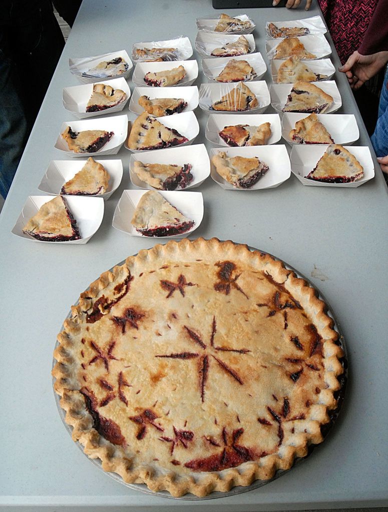 A full blackberry pie sits next to serving trays of individual slices ready for the pie-eating public. (Keith Thorpe/Peninsula Daily News)