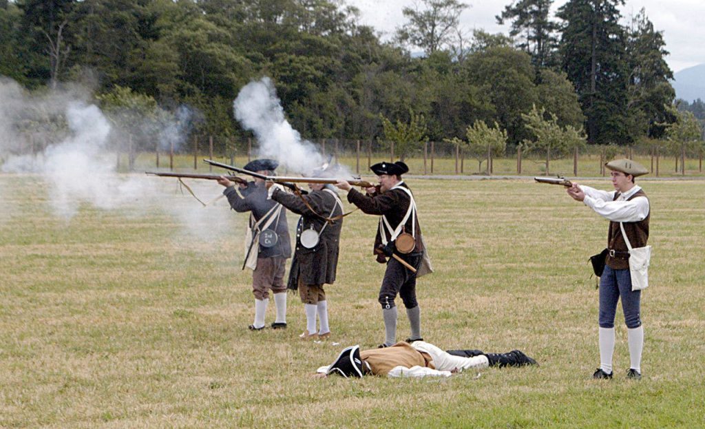 The 2nd Connecticut Regiment of Militia fires upon advancing redcoats during a re-creation of the April 19, 1775, battles of Lexington during the opening day of the inaugural colonial festival at George Washington Inn in 2015. (Chris McDaniel/Peninsula Daily News)