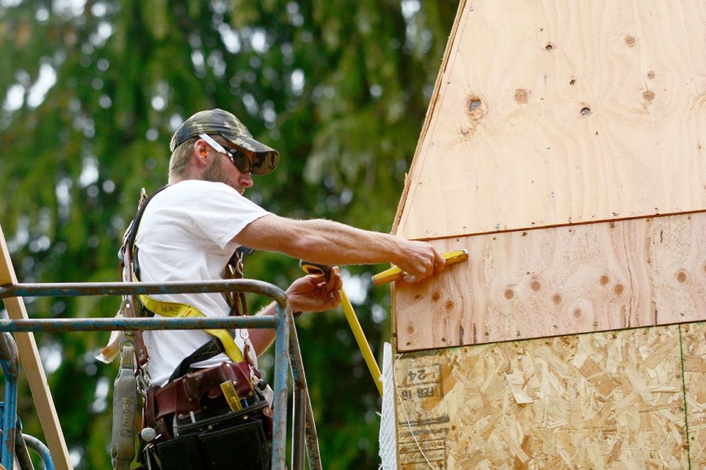 Eric Monroe of Dan Nieman Construction works on the roof at the Worthington Mansion in Quilcene on Wednesday. (Jesse Major/Peninsula Daily News)