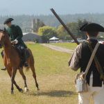 Paul Revere, portrayed by Colton Crouch of Carlsborg, rides the horse Reggie past militiaman Dave Rieve of Kent during a reenactment of Revere&rsquo;s famous ride as part of the Northwest Colonial Festival near Agnew. (Keith Thorpe/Peninsula Daily News)