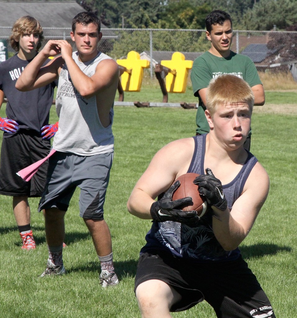 Dave Logan/for Peninsula Daily News Port Angeles running back Trevor Shumway, front, looks to cut upfield after taking a handoff from quarterback Matthew Warner, back left.