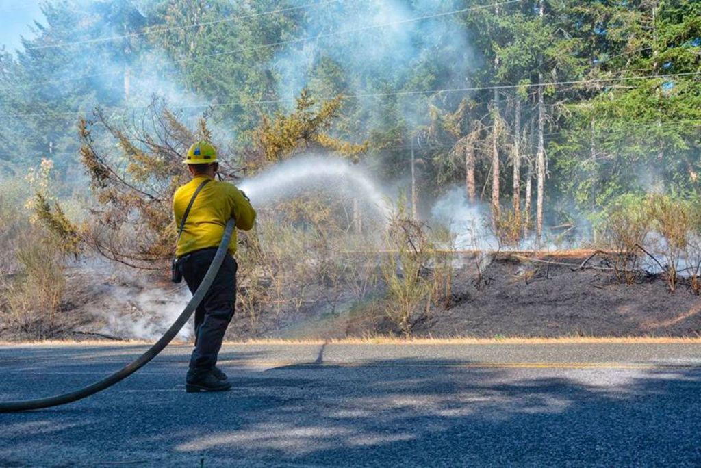 The brush fire on Power Plant Road west of Port Angeles on Tuesday caused state Highway 112 to be blocked for about an hour. (Jay Cline/Clallam County Fire District No. 2)