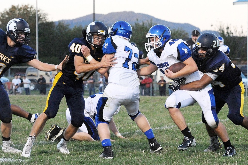 Lonnie Archibald/for Peninsula Daily News Forks&rsquo; Eden Cisneros, far right, tackles a Chimacum ball carrier as teammate Garrison Schumack tries to get off a block during a 2015 game.