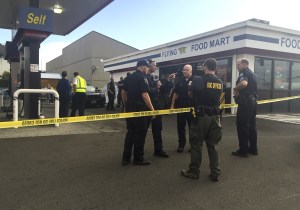 Officers are stationed outside the West Kelso Flying K gas station after an officer-involved shooting there Wednesday. A Kelso patrolman shot and killed a man who attacked a customer, a store clerk and the officer himself with a walking stick. (Lauren Kronebusch/The Daily News via AP)