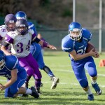 Steve Mullensky/for Peninsula Daily News Chimacum&rsquo;s Eliajah Avery, right, runs around a block by Aaron Serrato (lower left) during a 2015 game against the Sequim Wolves.