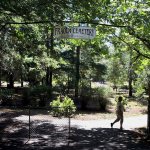 Joanne Clark, the secretary/treasurer for the Fraola Cemetery, closes the gate of the cemetery in Olalla on Aug. 5. The Fraola Cemetery, established in 1929, is still used for burials. (Larry Steagall/Kitsap Sun via AP)