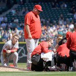 Los Angeles Angels infielders Andrelton Simmons, left, and Mike Trout kneel nearby as starting pitcher Matt Shoemaker is treated at right after being hit by a line drive from Seattle Mariners&rsquo; Kyle Seager in the second inning of a baseball game, Sunday, Sept. 4, 2016, in Seattle. (AP Photo/Elaine Thompson)