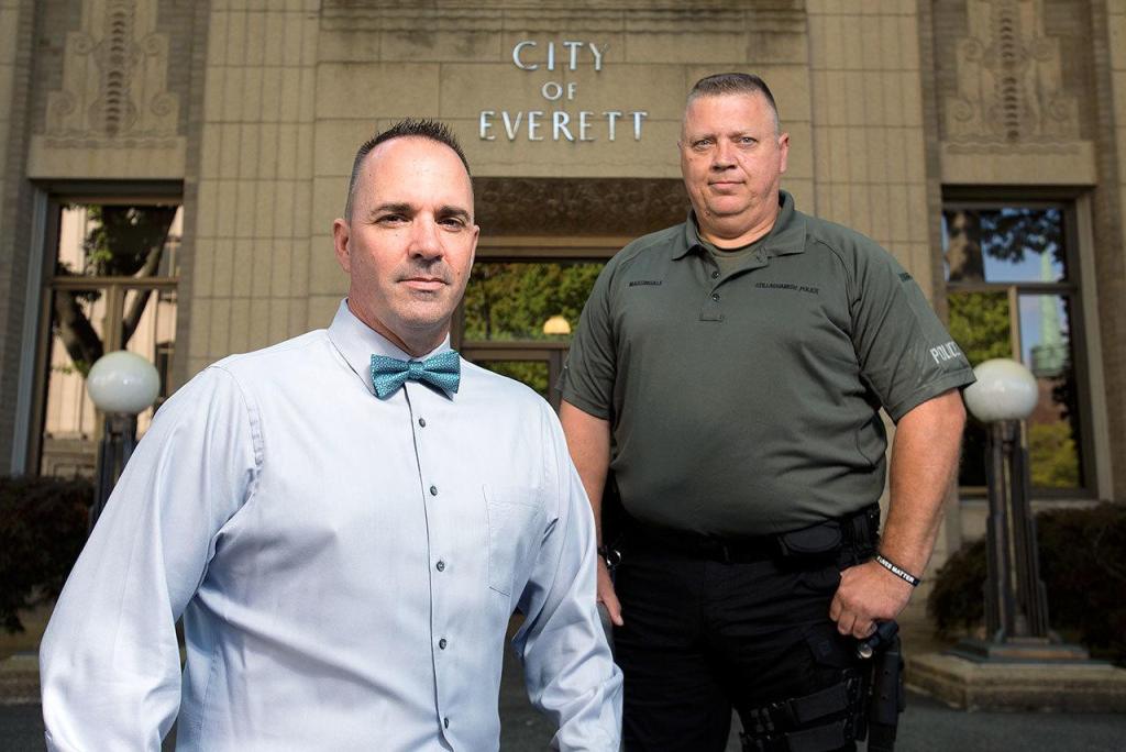 Everett Police Detectives Mike Atwood, left, and Jim Massingale, now a patrolman with the Stillaguamish Police Department, stand in front of the Everett Police Department on Tuesday in Everett. After two years of investigating, they are confident they traced the lost 9/11 flag and confirmed its authenticity. The flag is going back to the National September Memorial & Museum. (Andy Bronson/The Herald)