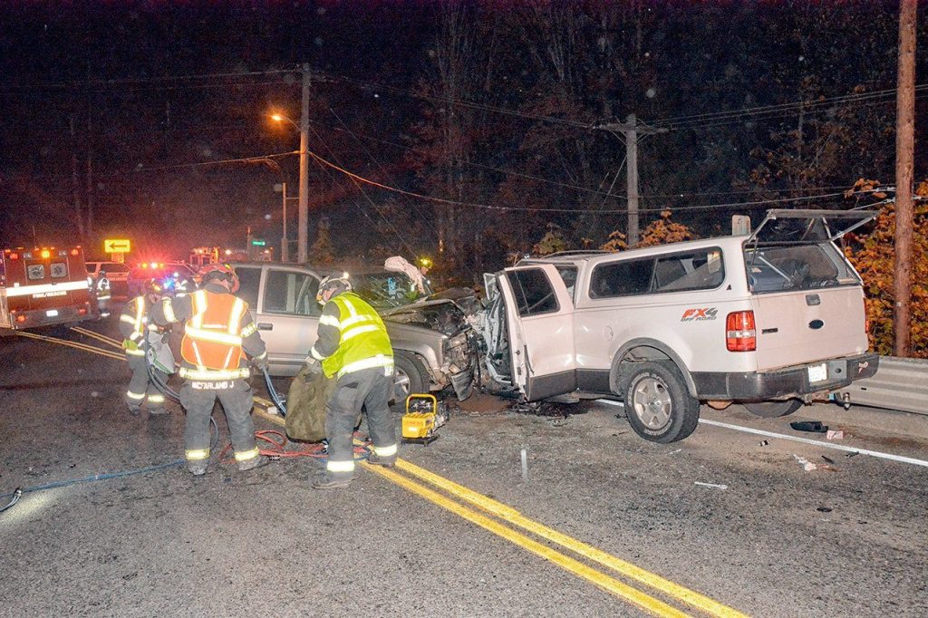 Personnel from Clallam Fire District No. 2 clean up following a two-vehicle head-on collision near the east end of the Elwha River Bridge on U.S. Highway 101 at 8:30 p.m. Friday. (Jay Cline/Clallam Fire District No.2)