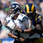 Seattle Seahawks quarterback Russell Wilson, left, is hit by Los Angeles Rams defensive end William Hayes after passing during the first half an NFL football game at the Los Angeles Memorial Coliseum, Sunday, Sept. 18, 2016, in Los Angeles. (AP Photo/Kelvin Kuo)