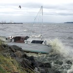Steve Mullensky/for Peninsula Daily News The first storm of Autumn blows strong enough to cause a cabin cruiser, anchored in the south end of Port Townsend Bay, to slip its anchorage and dash against the rocks along the Larry Scott Trail in Port Townsend on Friday. In the background, a boat from Vessel Assist, right, helps tow another boat that was in danger of being grounded on the beach, to get to deeper water.                                Steve Mullensky/for Peninsula Daily News                                 The first storm of autumn blew strong enough to cause a cabin cruiser, anchored in the south end of Port Townsend Bay, to slip its anchorage and dash against the rocks along the Larry Scott Trail in Port Townsend on Friday. In the background, a boat from TowBoatUS, right, helps tow another boat that was in danger of being grounded on the beach.