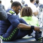 Seattle Seahawks quarterback Russell Wilson laces his shoe after getting his ankle taped following a play during the second half of an NFL football game against the Miami Dolphins, Sunday, Sept. 11, 2016, in Seattle. (AP Photo/Elaine Thompson)