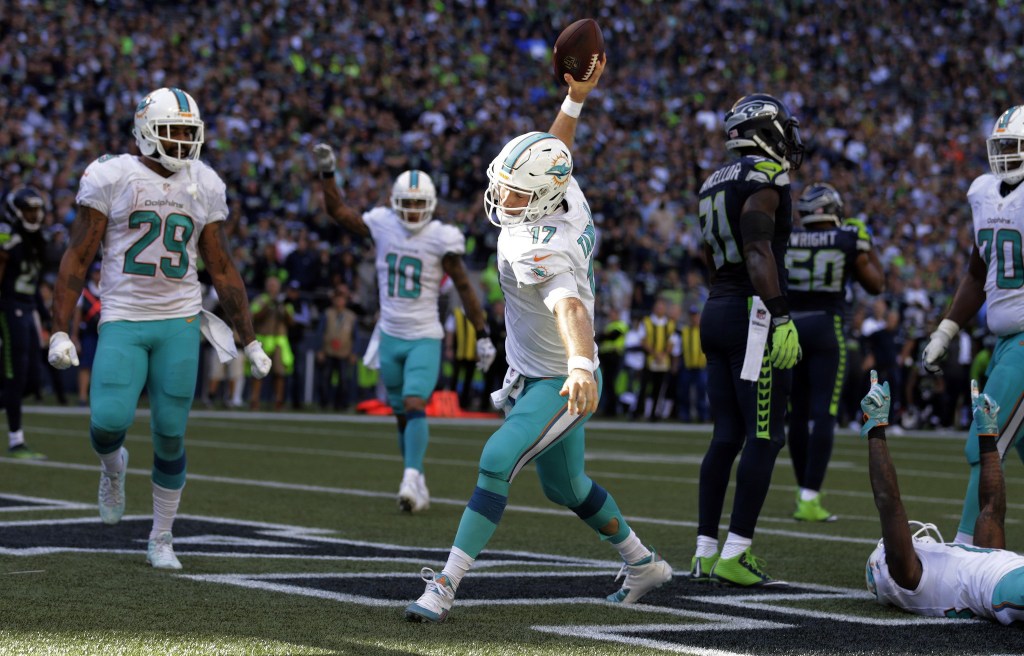 Miami Dolphins quarterback Ryan Tannehill (17) spikes the ball after scoring a touchdown against the Seattle Seahawks in the second half of an NFL football game, Sunday, Sept. 11, 2016, in Seattle. (AP Photo/Stephen Brashear)