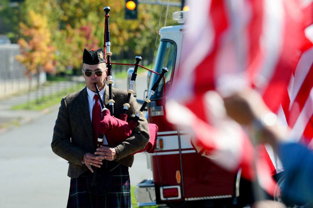 Rick McKenzie, a retired Coast Guard veteran, plays bagpipes in front of the Port Angeles Fire Department on Sunday. (Jesse Major/Peninsula Daily News)