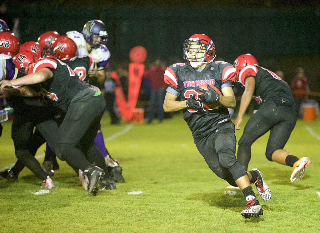 Steve Mullensky/for Peninsula Daily News Port Townsend&rsquo;s Jacob Boucher carries the ball during the Redhawks&rsquo; 27-26 loss to Sequim.