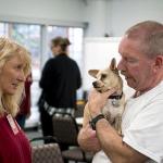 Welfare for Animals Guild volunteer Chris Clark talks to inmate Douglas Gallagher, who is holding Skeeter, a dog he trained. (Brian Harmon)