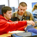Crescent High School science and year book teacher Brad Ahrndt works with senior Austin Hedger-Irvins on Monday. Crescent High School was recently recognized as a school of distinction. (Jesse Major/Peninsula Daily News)