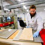 Joel Lippold, product developer with the Composite Recycling Technology Center, makes a construction composite panel Monday as part of CRTC&rsquo;s research and development effort. (Jesse Major/Peninsula Daily News)