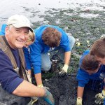Paul Rogers of the state Department of Fish and Wildlife gets help from YES! students digging for shellfish for a Wooden Boat Festival display.