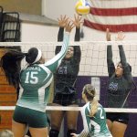 Keith Thorpe/Peninsula Daily News Port Angeles&rsquo; Nizhoni Wheeler, left, tips the ball across the net as Sequim&rsquo;s Adrienne Haggerty and Kaila Sundquist try to block during the second game of their match on Thursday night in Sequim. Looking on at the net was Port Angeles&rsquo; Callie Hall.