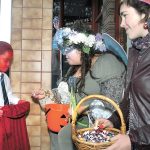 Eight-year-old Hayden Hull of Port Angeles, left, receives candy from Izzy Gray, center, and Jena Klein in front of the InSpired! gift store during Halloween festivities in downtown Port Angeles in 2015. (Keith Thorpe/Peninsula Daily News)