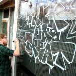 Zach Hanson, an employee of Bar N9ne restaurant and bar in downtown Port Angeles, decorates the business&rsquo; front window with a Halloween theme Friday in preparation for Monday&rsquo;s holiday. (Keith Thorpe/Peninsula Daily News)