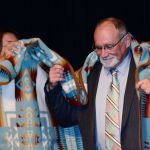 Jamestown S&rsquo;Klallam tribal members wrap a blanket around state Sen. Jim Hargrove, honoring him for his more than 30 years in the state Legislature, during the Clallam County Democrats&rsquo; Franklin & Eleanor Roosevelt Dinner at 7 Cedars Casino on Saturday. (Jesse Major/Peninsula Daily News)