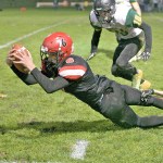 Steve Mullensky/for Peninsula Daily News Port Townsend&rsquo;s Gerry Coker, dives forward after being tackled during a game with Vashon last month at Memorial Field. The Redhawks host Charles Wright tonight at 7 p.m.