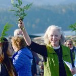 The Rev. Gail Wheatley of St. Andrew&rsquo;s Episcopal Church uses a cedar branch dipped in the mouth of the Elwha River to bless those who attended an event to show solidarity with the Standing Rock Sioux Tribe on Thursday. Wheatley organized the event. (Jesse Major/Peninsula Daily News)