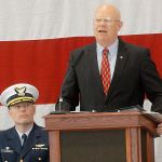 Retired U.S. Coast Guard Rear Adm. Richard Gromlich, right, delivers the keynote address during Friday&rsquo;s Veterans Day ceremony in the hangar of U.S. Coast Guard Air Station/Sector Field Office Port Angeles. Looking on at left is Cmdr. Mark Hiigel, commanding officer of the station. (Keith Thorpe/Peninsula Daily News)