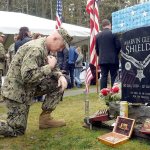 Capt. Christ Kurgan crosses himself beside the grave of Medal of Honor recipient Marvin Shields during the annual Veterans Day ceremony at the Gardiner Cemetery on Friday. (Cydney McFarland/Peninsula Daily News)