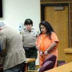 Clallam County corrections deputy Alicia Newhouse helps Ramona Ward to her seat during a hearing in Port Angeles on Monday. (Rob Ollikainen/Peninsula Daily News)