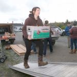 Quilcene&rsquo;s Aimee Firth carries a load of produce into a truck bound for the Standing Rock Sioux Reservation in support of the pipeline protesters. (Steve Mullensky/for Peninsula Daily News)