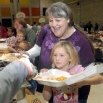 Lynette Schaner of Port Angeles and her granddaughter, Kalika Mulvaine, 10, go through the serving line during the annual community Thanksgiving dinner in the gym of Queen of Angels Catholic Church on Thursday in Port Angeles. (Keith Thorpe/Peninsula Daily News)