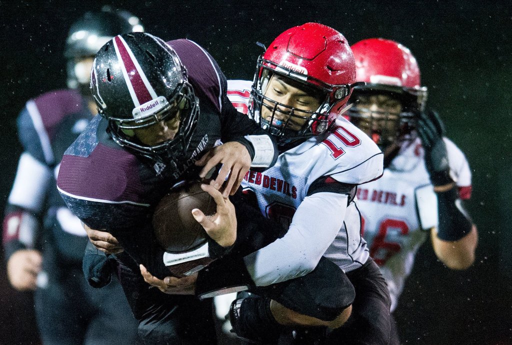 Photo by Evan Abell/Bellingham Herald                                Neah Bay&rsquo;s Rwehabura Munyagi, right, tackles Lummi&rsquo;s Raven Borsey Saturday at Everett Memorial Stadium in Everett.