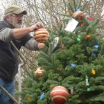 Volunteer Michael Rosser helps decorate the Port Townsend Christmas tree Tuesday to prepare for the weekend&rsquo;s holiday events. (Cydney McFarland/Peninsula Daily News)
